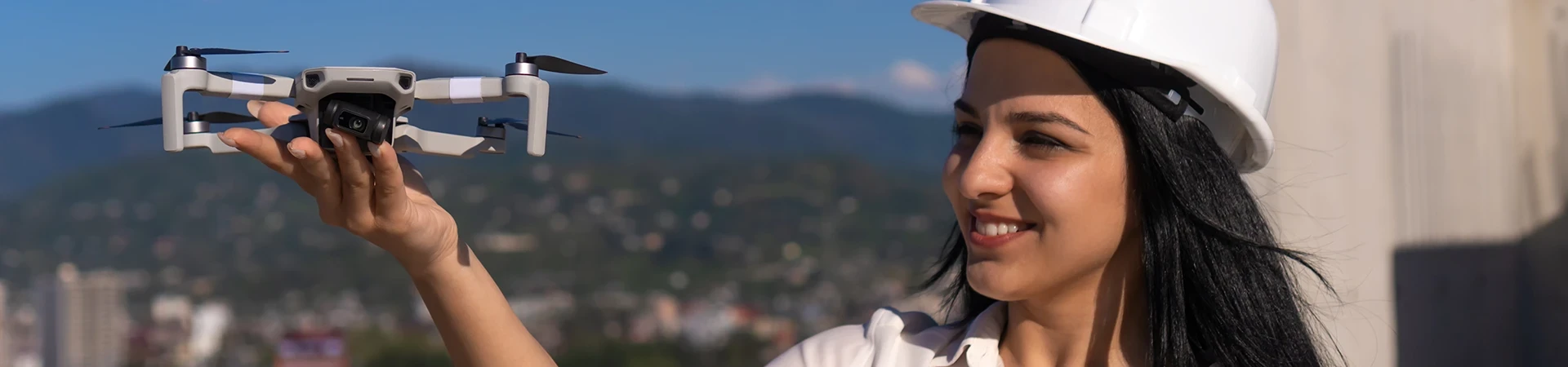 Pilot Unmanned Aircraft Systems Certificate female specialist in a hard hat launches a drone at a construction site