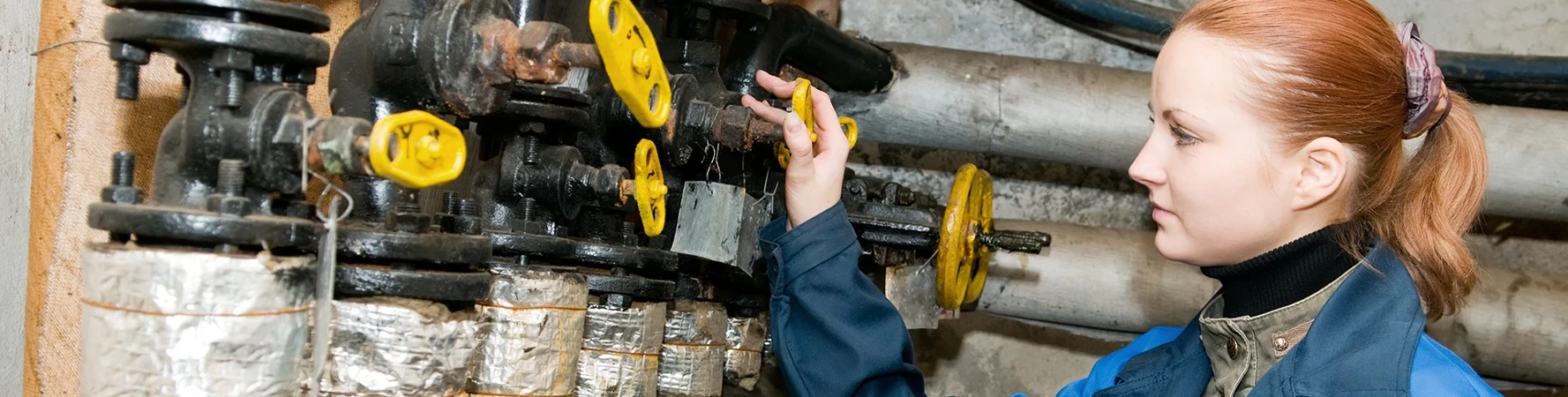 IST Certificate, CTE worker adjusting and checking heating system equipment in a boiler room